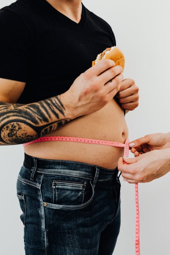 Man with Hamburger Getting his Waist Measured 